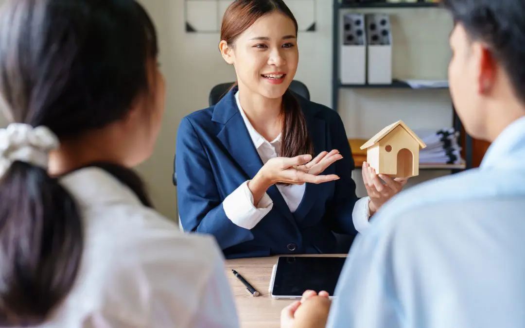 Woman sits at table discussing home options with clients.