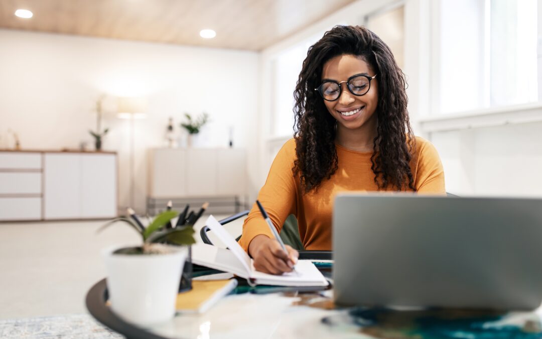 A smiling woman is sitting at her desk.